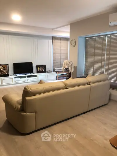 Spacious living room with modern beige sofa and entertainment center