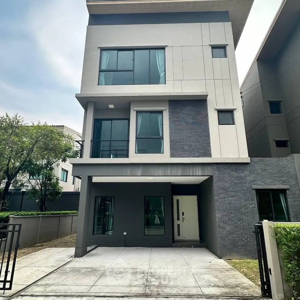 Modern three-story house with sleek design and large windows in a suburban neighborhood.