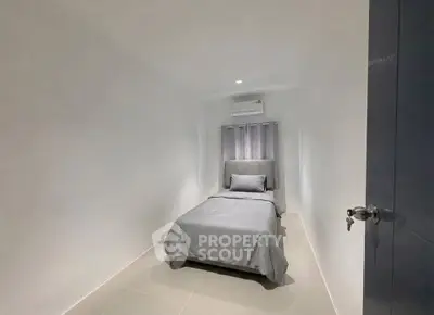 Cozy minimalist bedroom with single bed and air conditioning in modern apartment.
