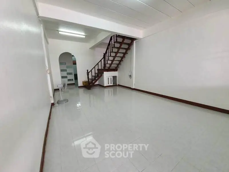 Spacious interior with sleek staircase and tiled flooring, perfect for modern living.