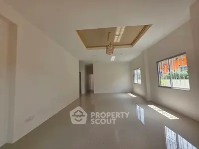 Spacious modern living room with large windows and elegant ceiling design