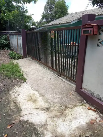Charming suburban home with gated entrance and lush greenery, perfect for privacy and tranquility.