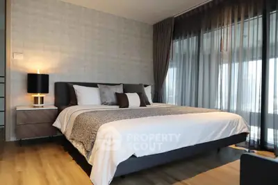Luxurious bedroom with modern decor and large windows offering natural light.