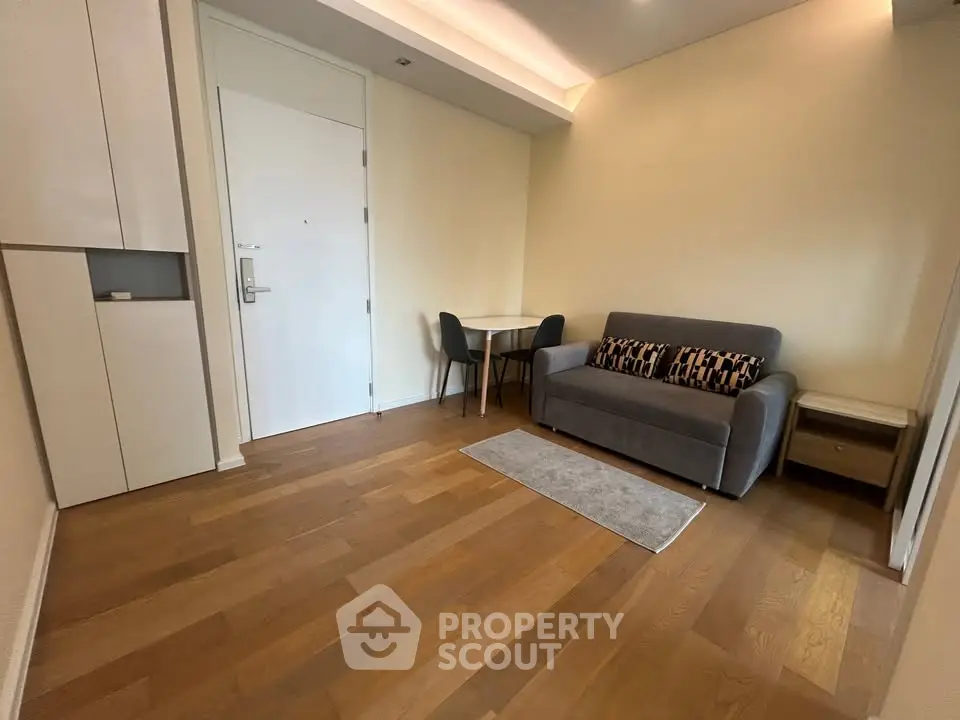 Modern living room with wooden flooring, cozy sofa, and dining area in a stylish apartment.