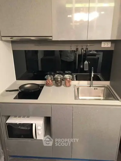 Modern compact kitchen with sleek cabinetry and built-in appliances, perfect for urban living.