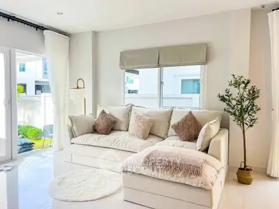 Bright and cozy living room with plush sofa and natural light, perfect for relaxation.