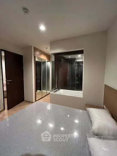 Modern bedroom with glass-walled bathroom and sleek design