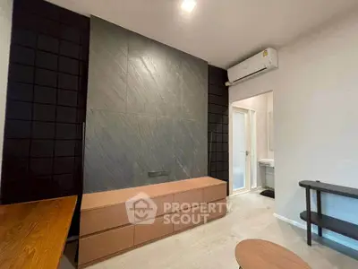 Modern living room with sleek design and air conditioning unit, featuring stylish furniture and contemporary decor.