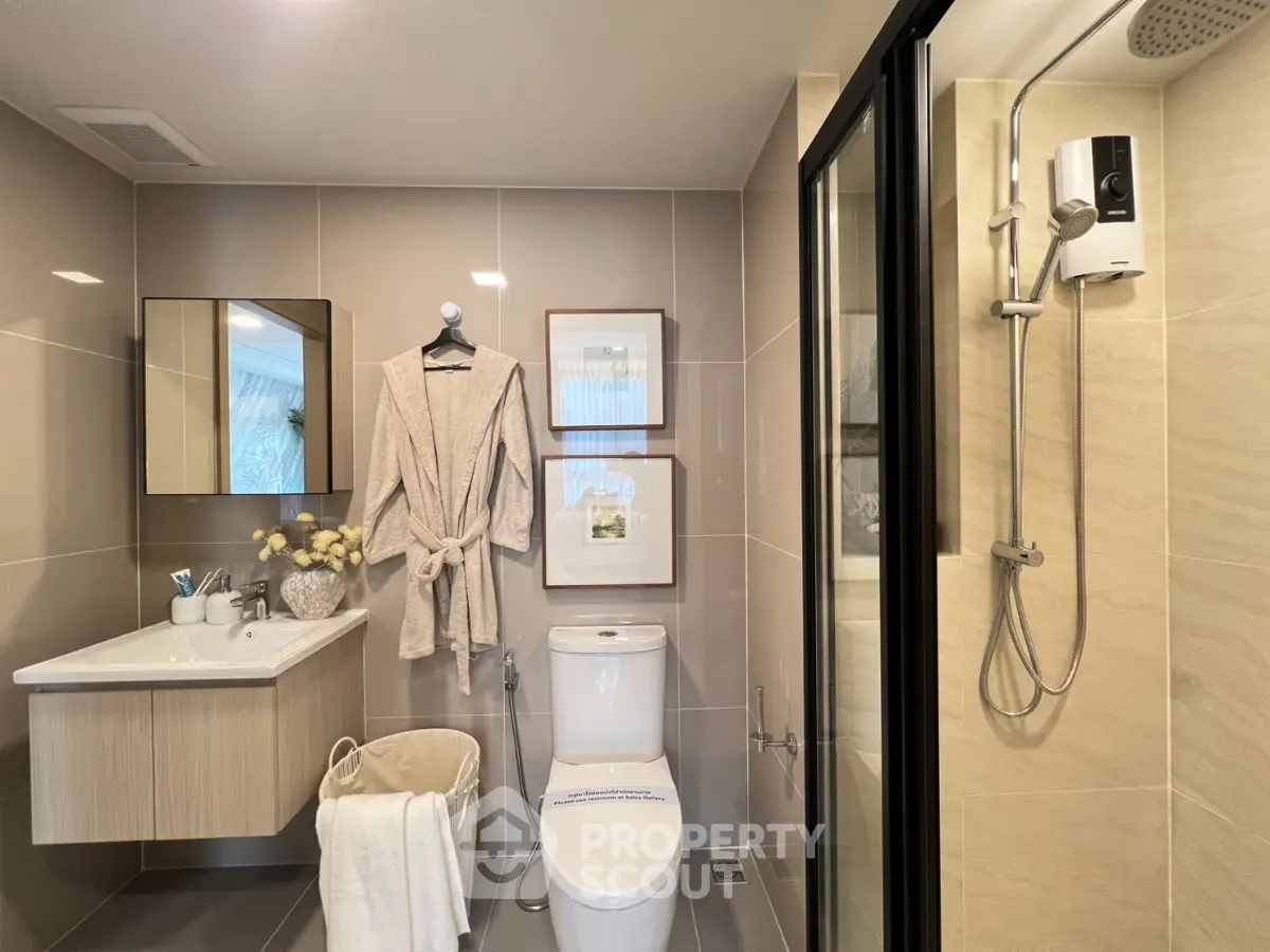 Modern bathroom with sleek fixtures and elegant decor, featuring a shower and vanity area.