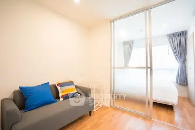 Modern apartment with cozy living room and sliding glass door to bedroom, featuring stylish decor.