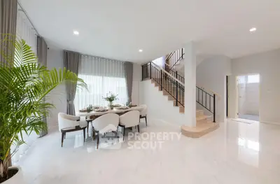 Spacious modern dining area with elegant staircase and natural light