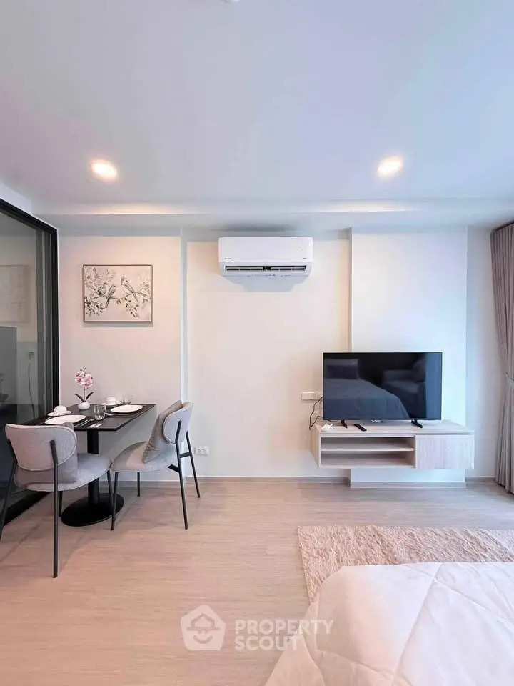 Modern living room with dining area and air conditioning in a stylish apartment.