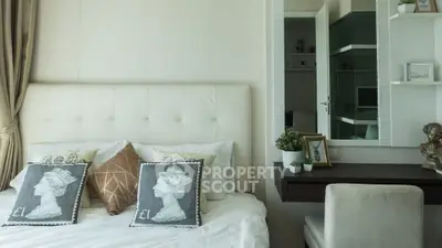Elegant bedroom with plush headboard and stylish decor, featuring a cozy workspace and modern accents.