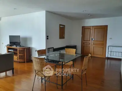 Spacious living room with wooden flooring and modern furniture in a stylish apartment.