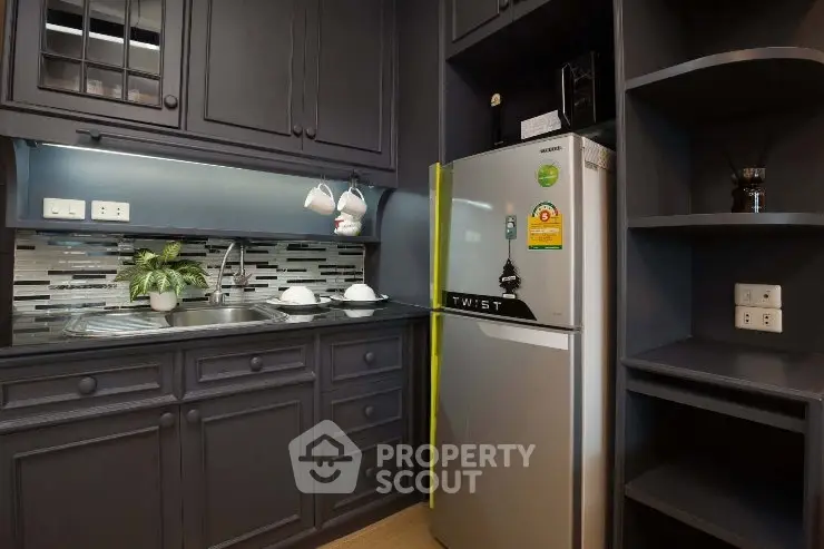 Modern kitchen with sleek cabinetry and stainless steel appliances in a compact layout.