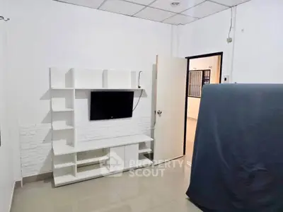 Modern living room with sleek TV unit and open door to hallway