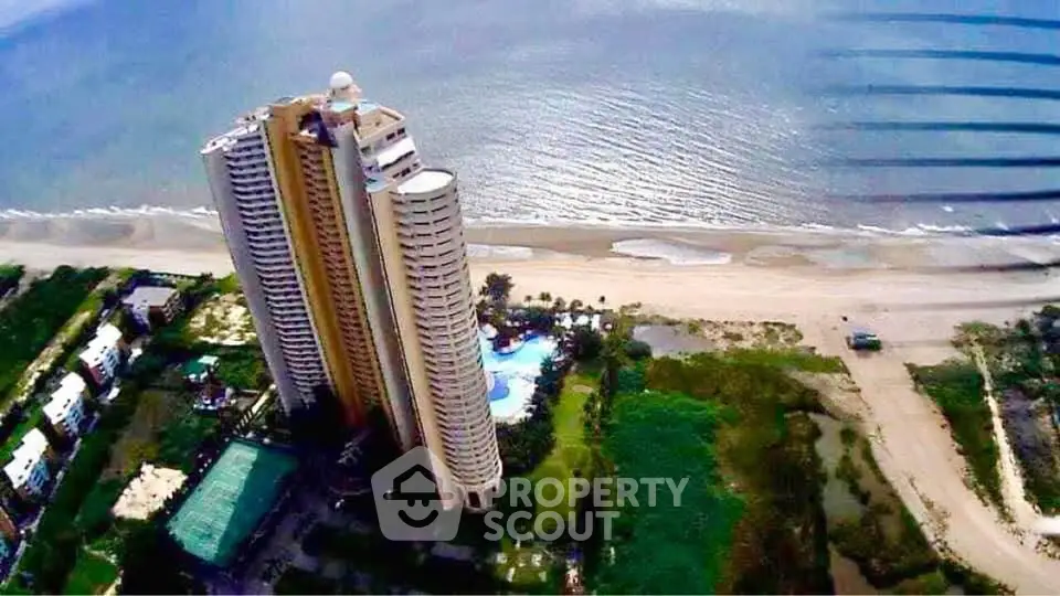 Stunning beachfront high-rise with panoramic ocean views and lush surroundings.