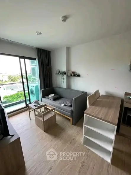 Modern living room with balcony view and stylish furniture in a cozy apartment.