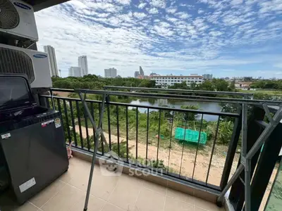 Spacious balcony with scenic view of city skyline and lush greenery, perfect for relaxation.