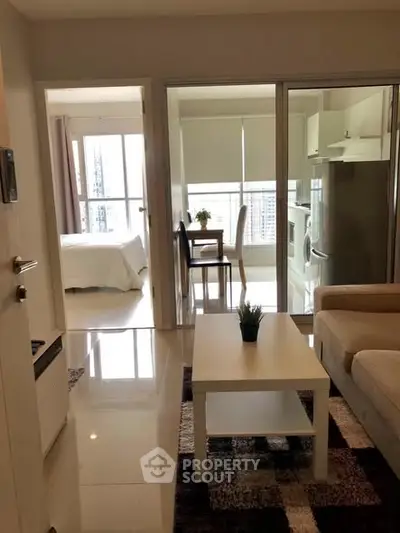 Modern apartment interior with living room, bedroom, and kitchen featuring sleek design and natural light.
