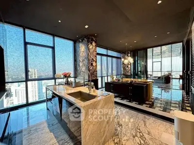 Luxurious open-layout kitchen with marble island and panoramic city views.