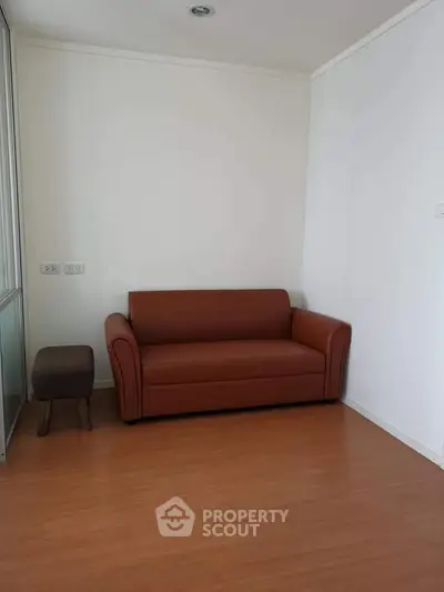 Cozy living room with brown leather sofa and wooden flooring