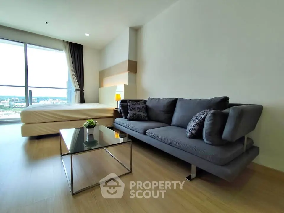 Modern living room with stylish sofa and large window offering stunning city view