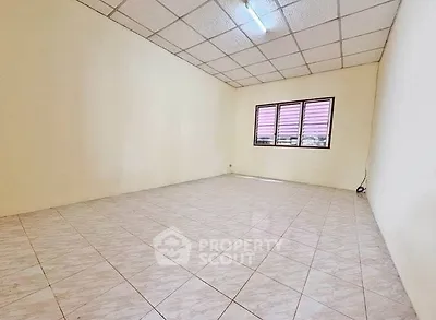 Spacious empty room with tiled flooring and large window