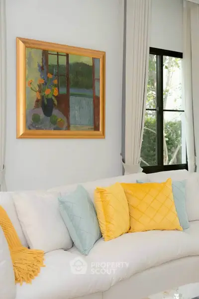 Elegant living room with stylish decor and colorful cushions, featuring a modern art piece on the wall.