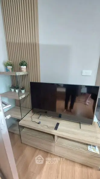 Modern living room with sleek TV setup and stylish wooden decor