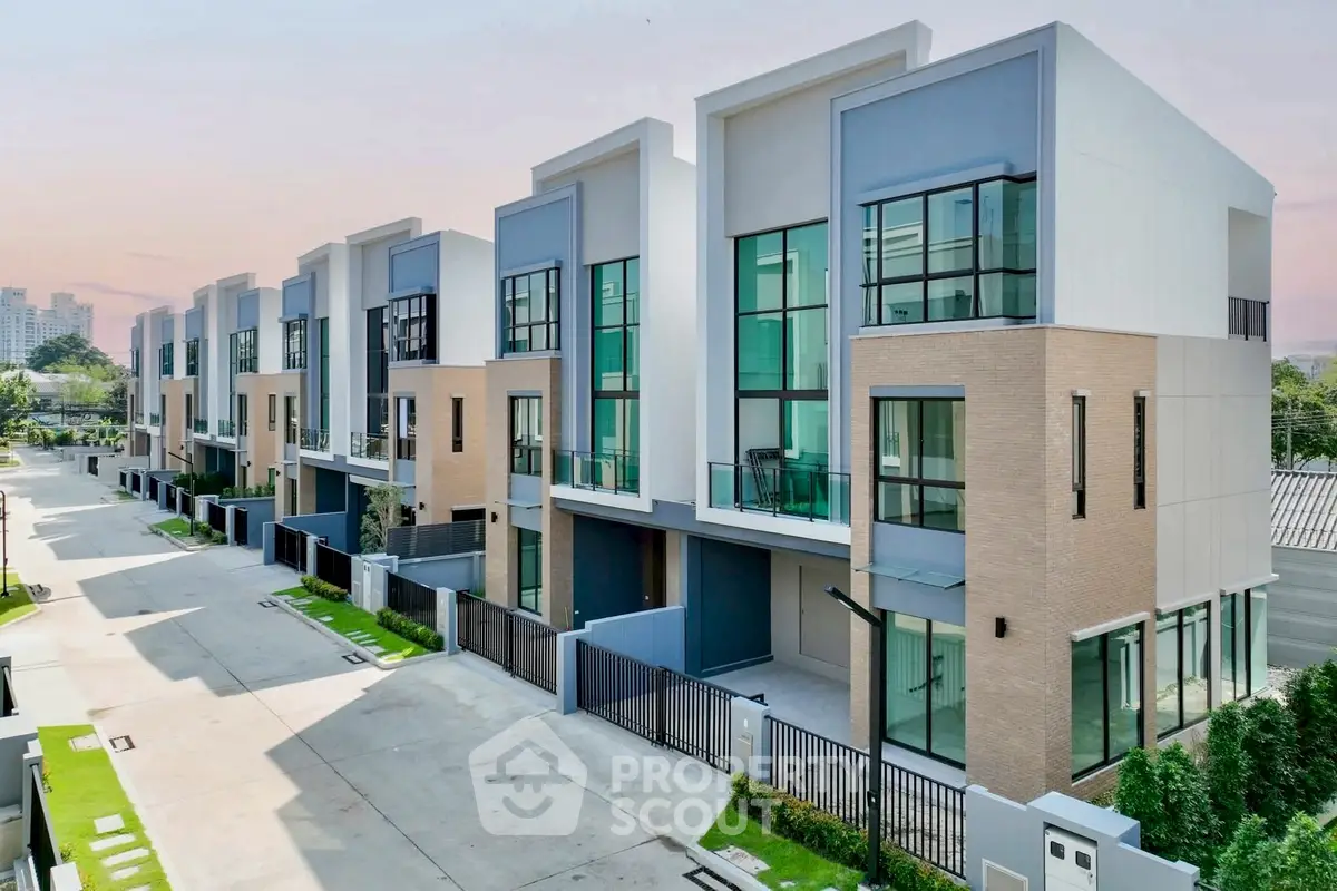 Modern townhouse complex with sleek design and large windows in a serene neighborhood.
