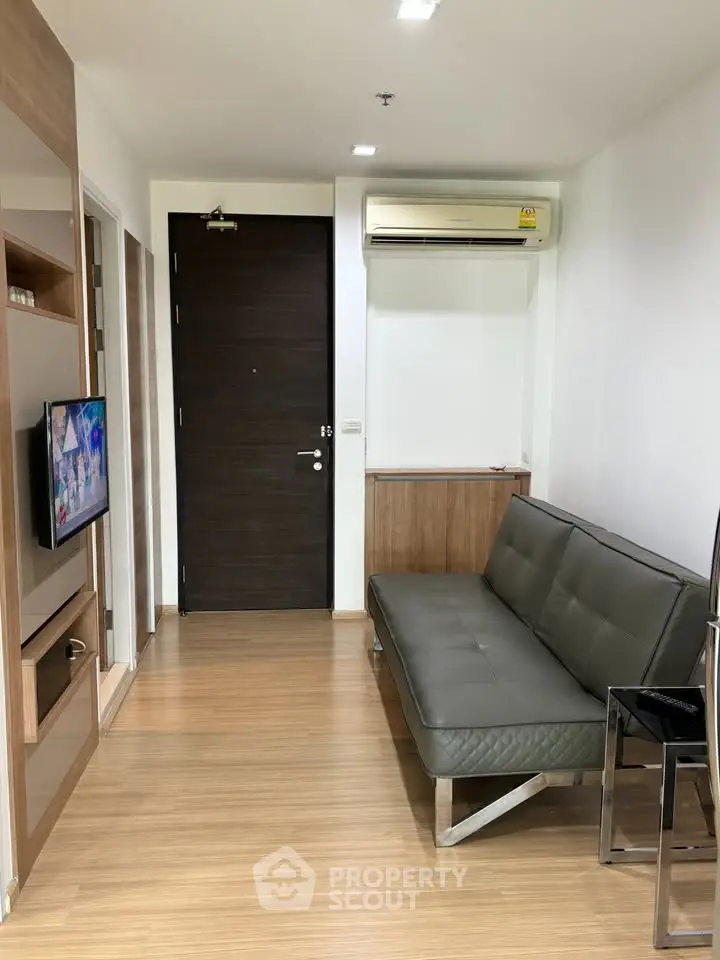 Modern living room with sleek sofa and wall-mounted TV in a stylish apartment.