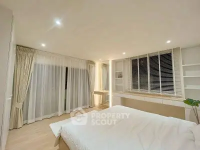 Spacious modern bedroom with elegant lighting and large windows