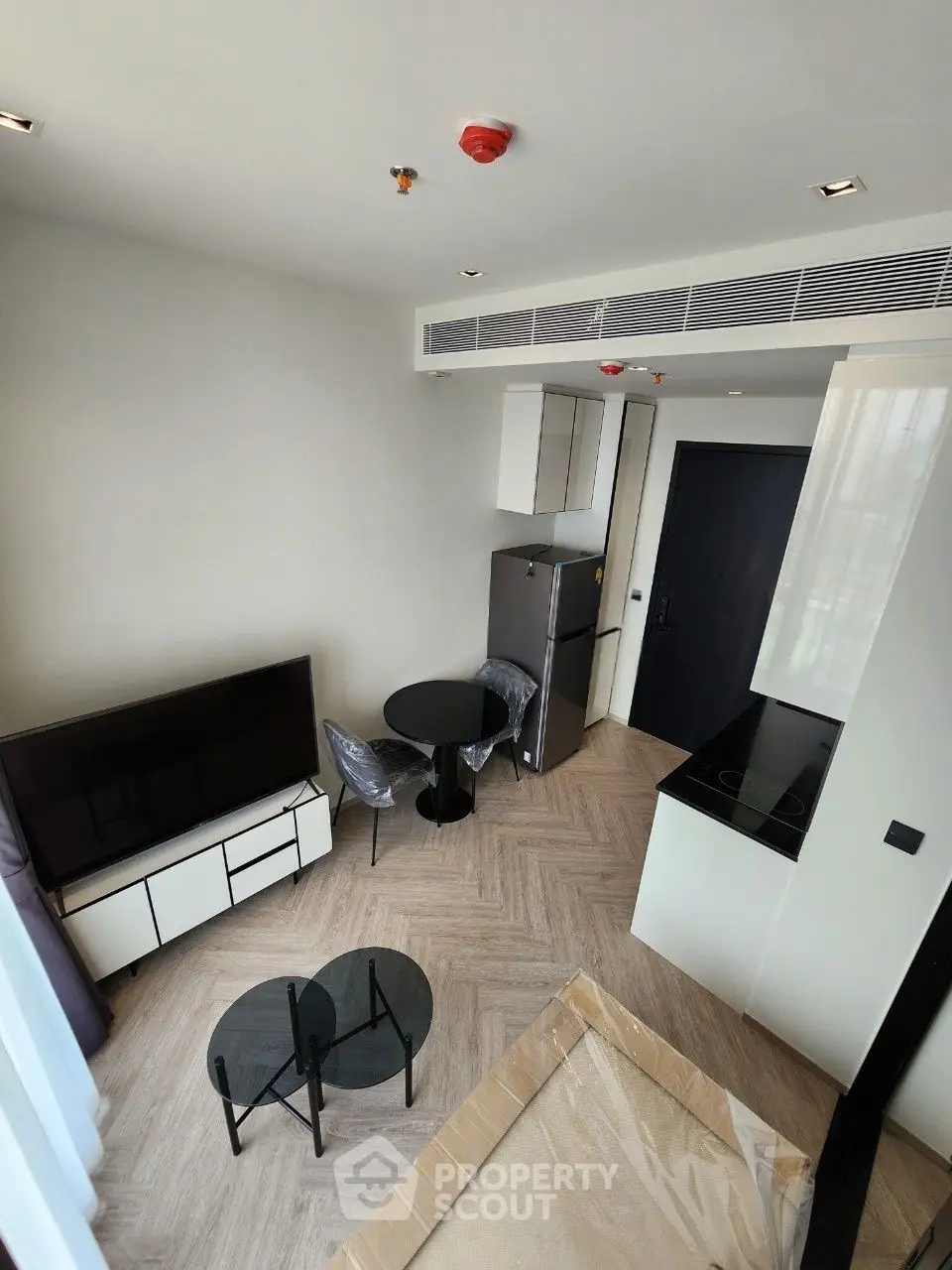 Modern living room with sleek furniture and open kitchen layout in a stylish apartment.