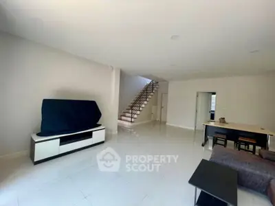 Spacious modern living room with sleek staircase and minimalist furniture