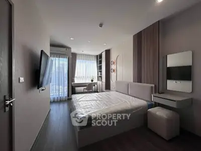 Modern bedroom with sleek design, large window, and wall-mounted TV in a stylish apartment.