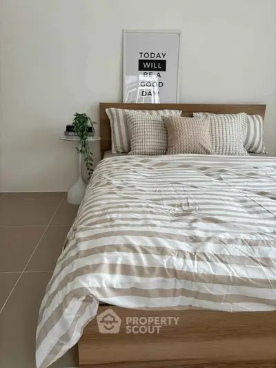 Cozy bedroom with stylish decor and striped bedding for a relaxing atmosphere.
