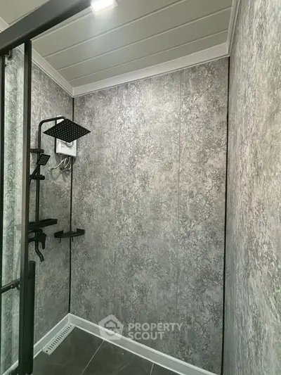 Modern bathroom with sleek shower design and gray textured walls.