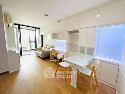 Modern living room with sleek furniture and natural light, featuring a cozy sofa and stylish dining area.