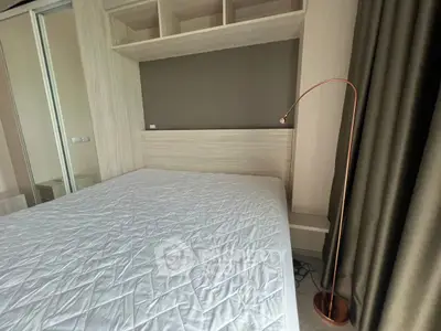 Modern bedroom with stylish floor lamp and built-in storage, perfect for urban living.
