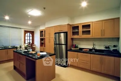 Spacious modern kitchen with wooden cabinets and stainless steel appliances