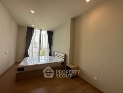 Spacious bedroom with large window and city view in modern apartment