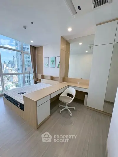 Modern bedroom with city view, featuring built-in desk and stylish decor.