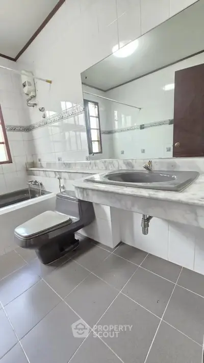 Spacious bathroom with modern fixtures and large mirror