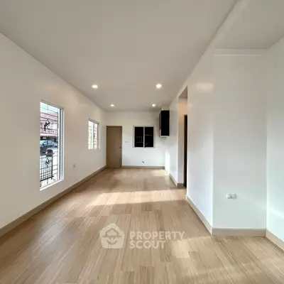 Spacious and bright living room with wooden flooring and recessed lighting