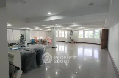 Spacious open-plan room with large windows and glossy floors, ideal for versatile living or office space.