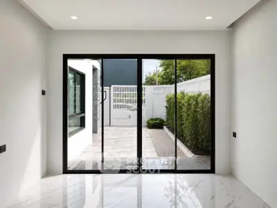 Modern interior with sliding glass doors opening to a private patio and garden view.