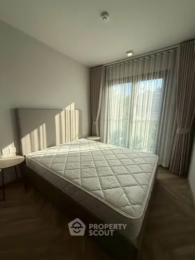 Bright and cozy bedroom with large window and modern decor