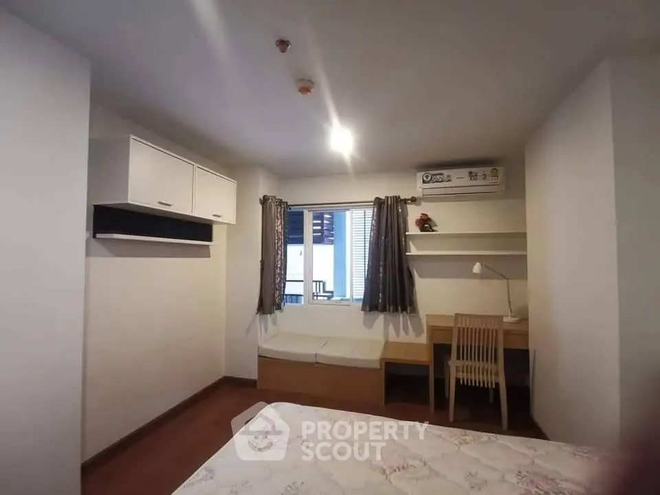 Cozy bedroom with study nook and air conditioning in modern apartment