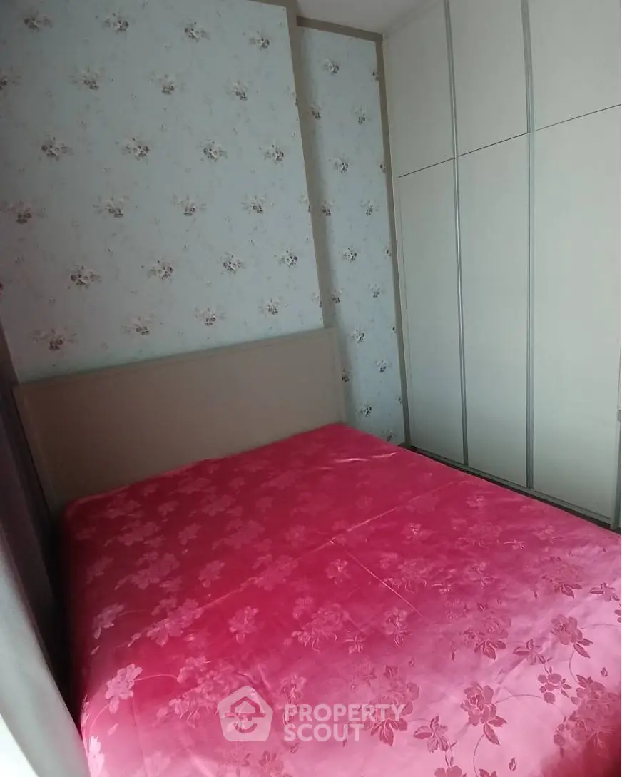 Cozy bedroom with floral wallpaper and built-in wardrobe